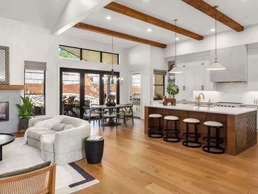 Modern kitchen remodel with dark island seating, statement pendants, and marble-style surfaces
