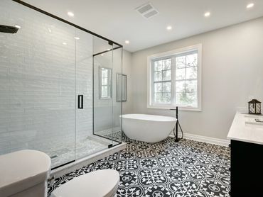 Luxury bathroom with freestanding tub, large picture window, double vanity, and Austin hill views