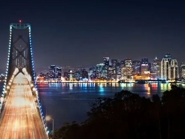 Skyline of San Francisco, CA, at night and the Bay Bridge