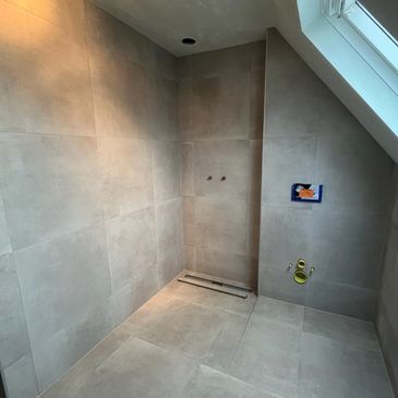 Aanbrengen van tegelwerk in een badkamer