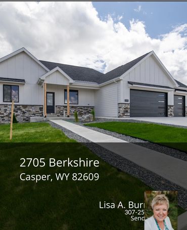 Modern white house with stone accents and a double garage under a cloudy sky.