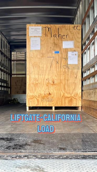 Large wooden crate labeled Maher inside a truck with liftgate.