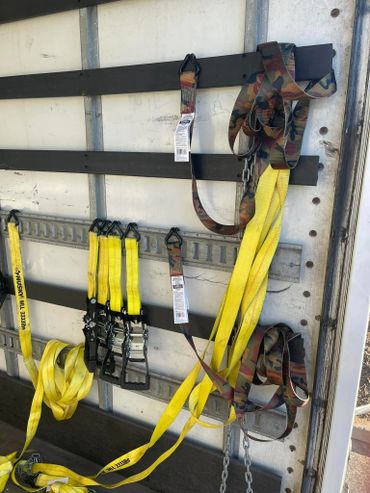 Yellow and camo ratchet straps hanging inside a truck.