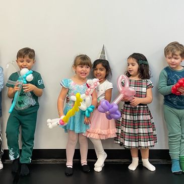 Group of children holding balloon animals at a birthday party in Milton.