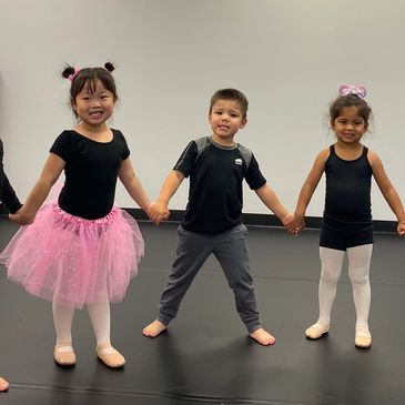 Group of three children holding hands in dance classes in Milton.