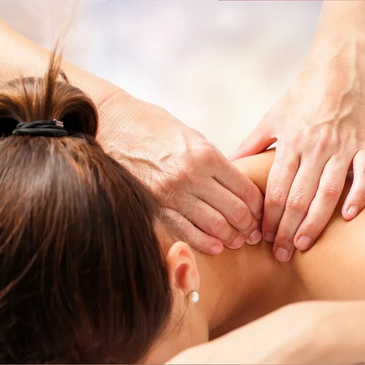 Female patient lying face down getting a massage on her shoulders by a Registered Massage Therapist.