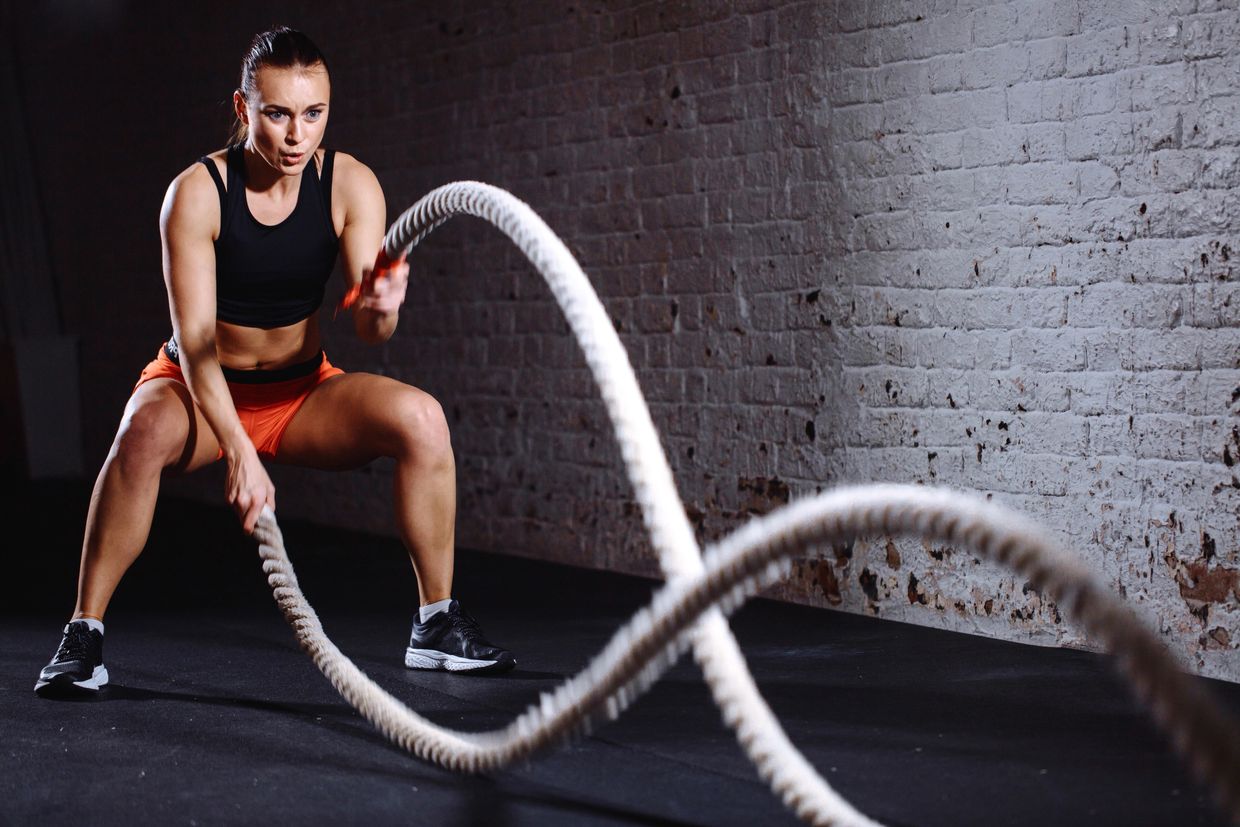 A female athlete is doing Battle Rope Workout.