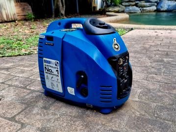 Compact blue portable generator on a driveway.