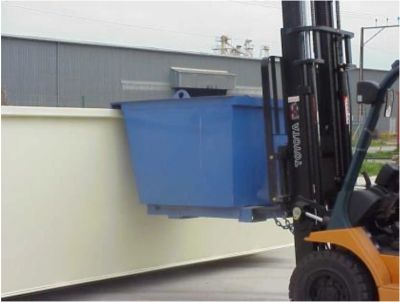Forklift lifting a blue container near a large white panel outdoors.