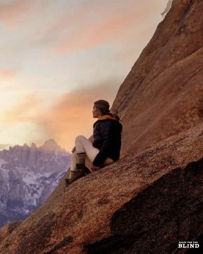 Drea is sitting on a rock behind her is Mount Whitney the highest mountain in LA in the distance.