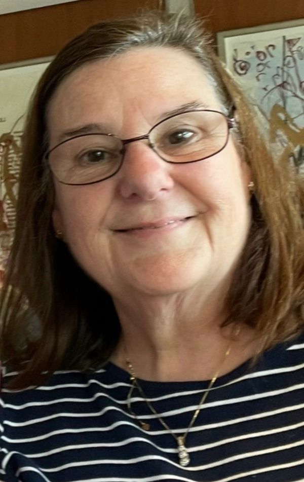 Smiling woman wearing glasses and a striped shirt.