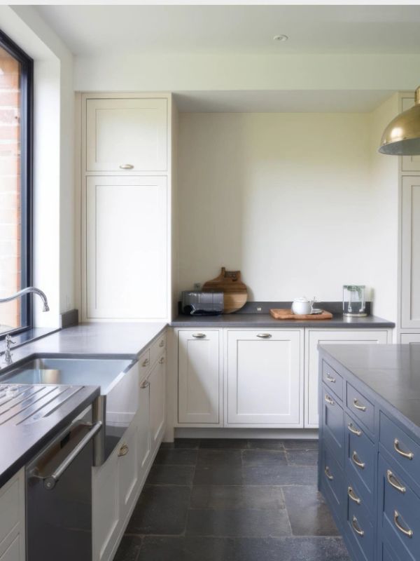 Modern kitchen with white cabinets and blue island.