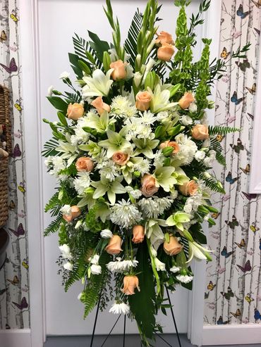 Elegant floral arrangement with peach roses and white lilies.
