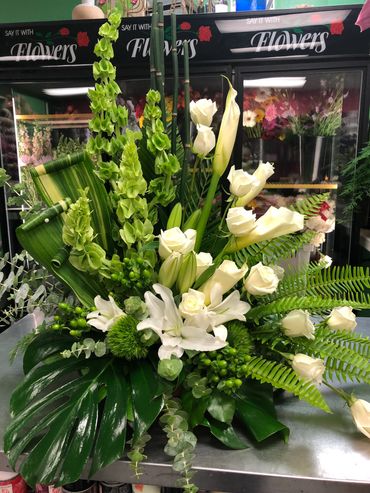 Elegant white and green floral arrangement in a flower shop.