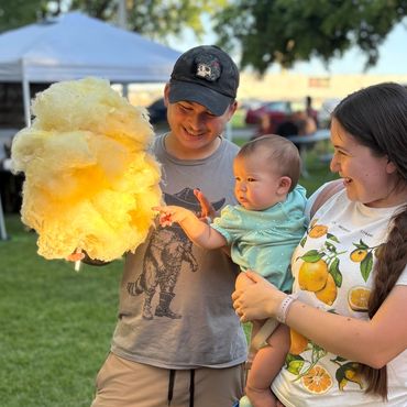 Family enjoying a sunny day at the park with cotton candy.