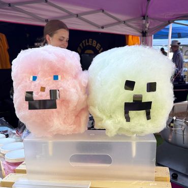Cotton candy with pixelated faces inspired by Minecraft characters at a market stall.