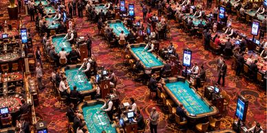 Busy casino floor with poker tables.