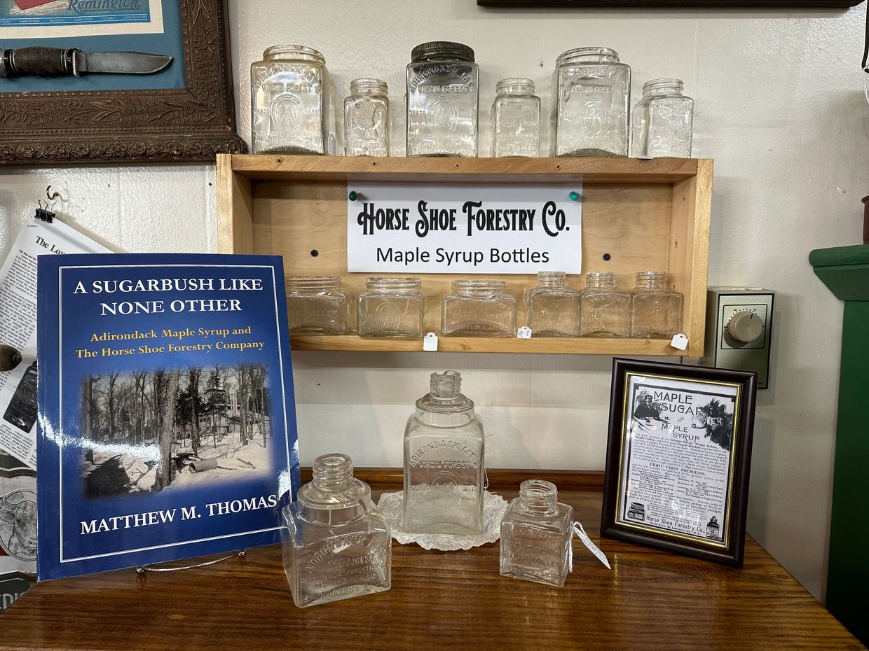 Horse Shoe Forest Co. display of maple syrup jars, books, advertisements and more. 