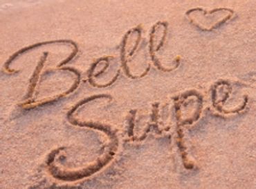 Names 'Bell' and 'Supe' written in sand with a heart.