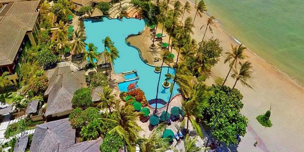 Aerial view of a beachside resort with a swimming pool.