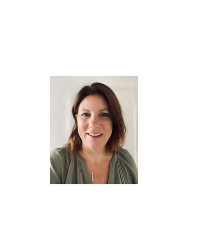 Smiling woman with shoulder-length brown hair, wearing a green top and a silver necklace.