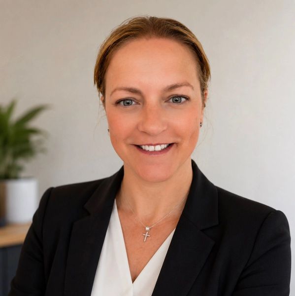 Professional woman smiling confidently in business attire.