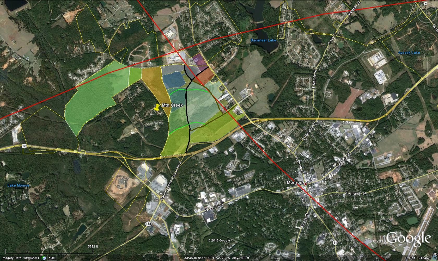 Satellite map of Monroe showing labeled lakes and highlighted land parcels.
