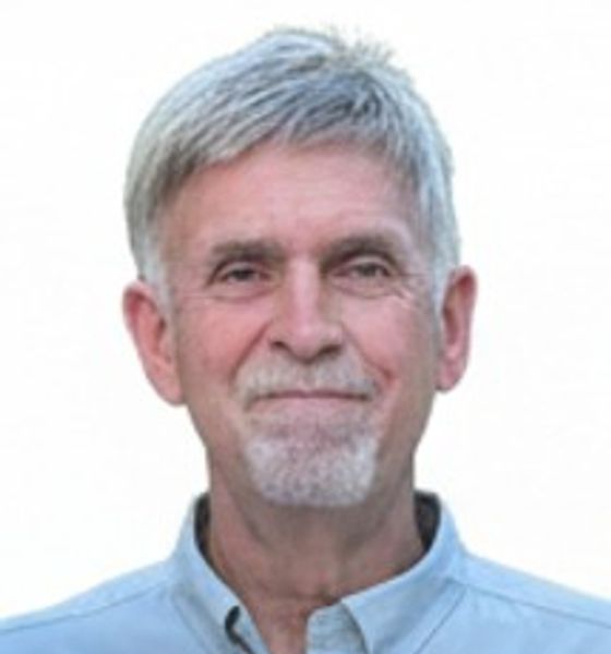 Smiling older man with gray hair and goatee.