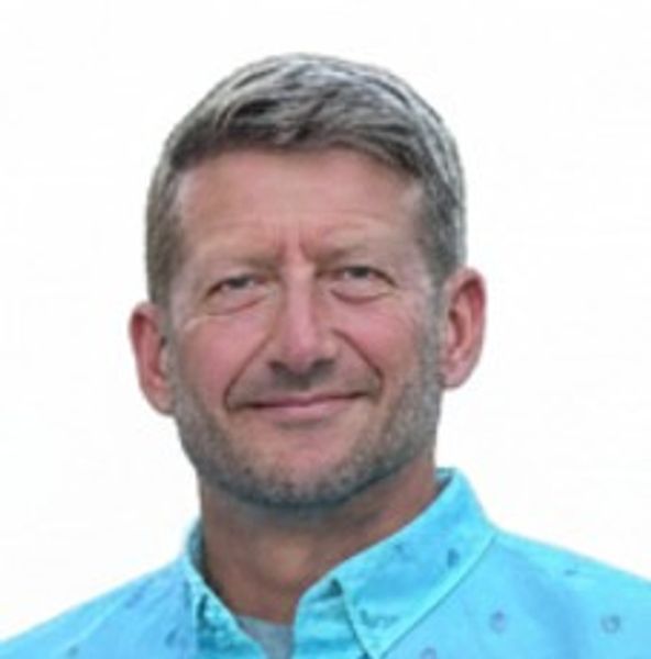 Smiling man in a blue shirt.