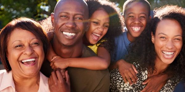 A joyful family of five smiling and enjoying time together outdoors.