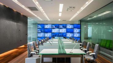Modern office workspace with multiple monitors and ergonomic chairs.