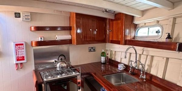 Cozy boat kitchen with wooden finishes and compact appliances.