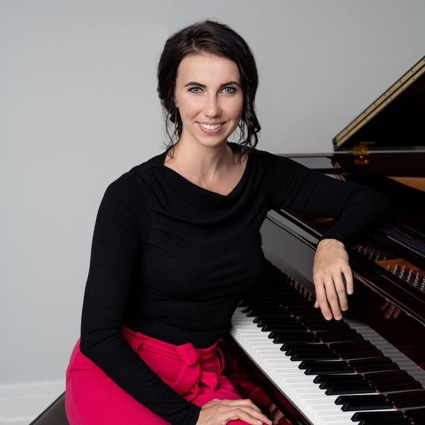 CEO and Founder of Magical Keys, Kasia Szczech-Dlugosz, sitting next to a piano.