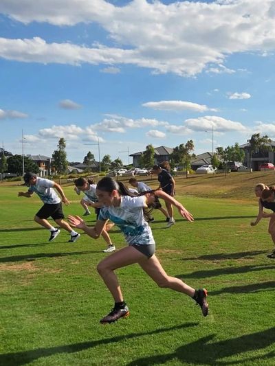 Group of people sprinting on a grassy field during daytime.