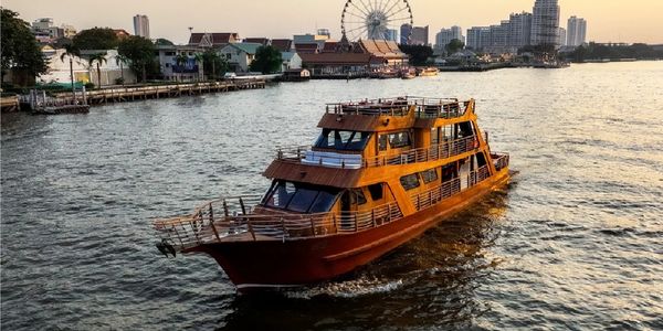 Wooden boat cruising on a river in a cityscape.