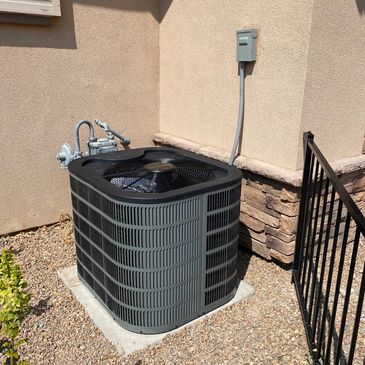 Outdoor air conditioning unit next to a house.