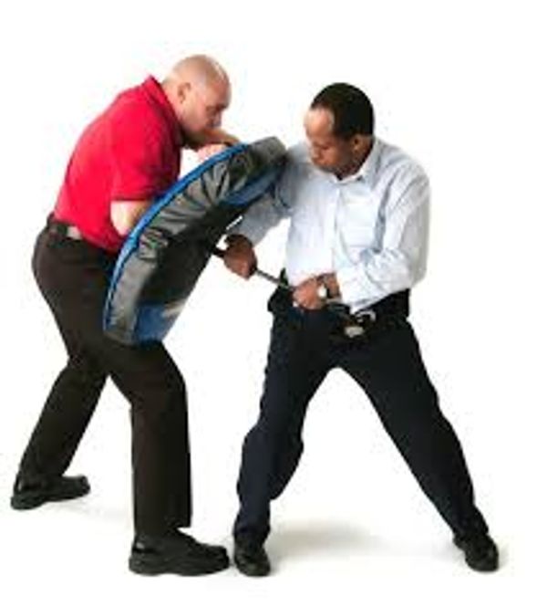 Two men practicing self-defense with a shield on a white background.