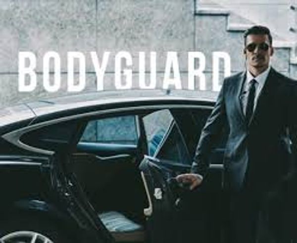 A professional bodyguard holding a car door open.