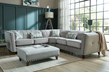 Elegant gray sectional sofa with matching ottoman in a modern living room.