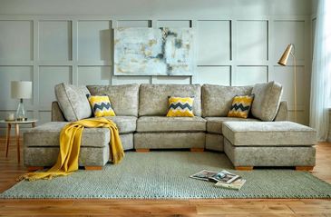 Modern beige sectional sofa with yellow and blue chevron pillows in a stylish living room.
