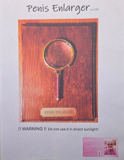 A humorous display of a magnifying glass labeled as a Penis Enlarger.