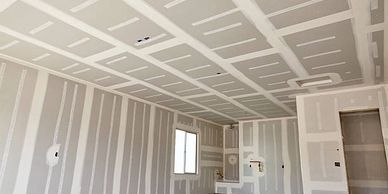 Interior room under construction with drywall installed.