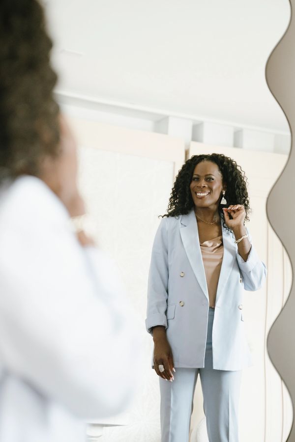 Woman smiling at her reflection in the mirror.