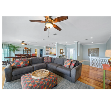 Spacious living room with gray sectional sofa and colorful cushions.