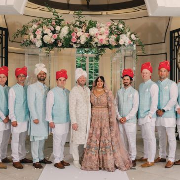 Indian wedding couple and groomsmen in traditional attire.