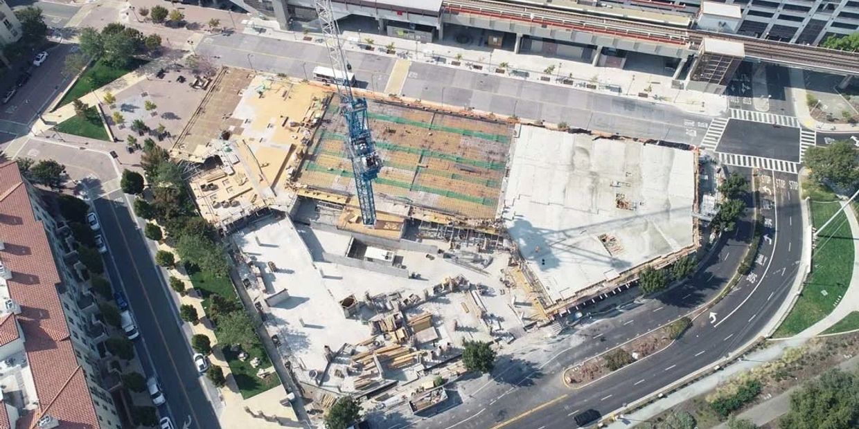 Aerial view of a construction site with a large crane and partially built structure.