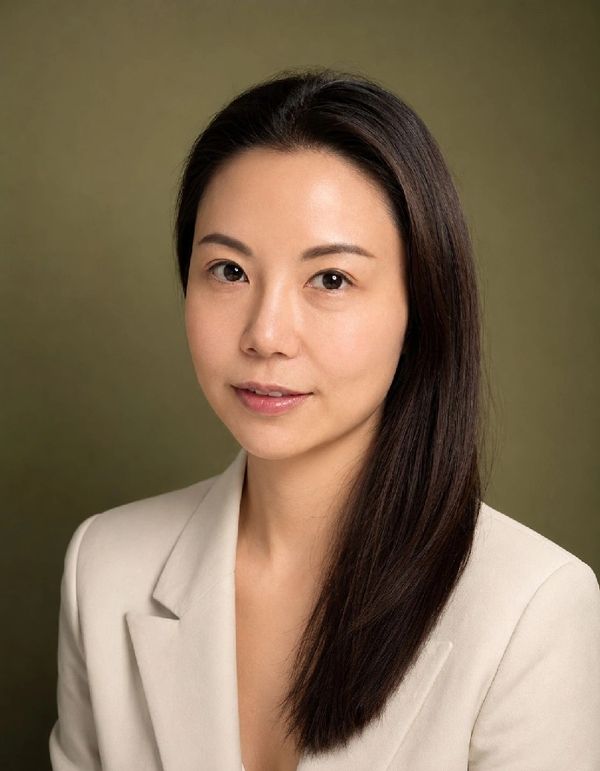 Professional portrait of a woman with straight dark hair wearing a beige blazer.