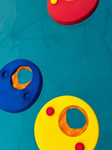 Colorful floating rings in a pool of clear blue water.