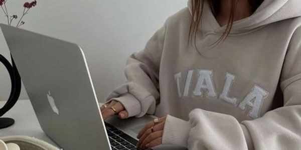a woman working on a laptop with a coffee next to her