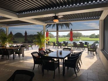 Luxury covered patio with black and white motorized screens and louvered pergola